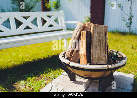 Close-up, scoppiettante fuoco con fiamme offuscata da ciocchi di legna in una pietra firepit. Foto Stock