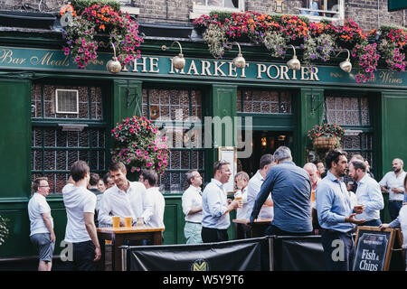 London, Regno Unito - Luglio 23, 2019: persone in piedi e bere al di fuori del mercato Porter pub inglese nel mercato di Borough, uno dei più grandi e più antiche cibo m Foto Stock