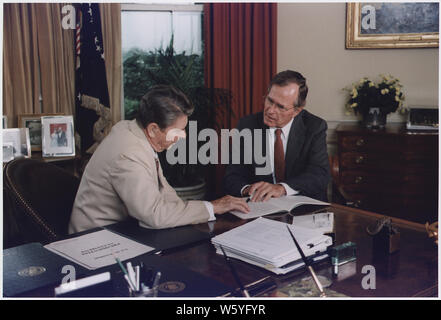 Vice Presidente Bush e il Presidente Reagan lavorando nell'ufficio ovale Foto Stock