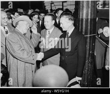 Vice presidente-eletto Alben W. Barkley scuote le mani con James V. Forrestal, con gli altri a guardare. Foto Stock