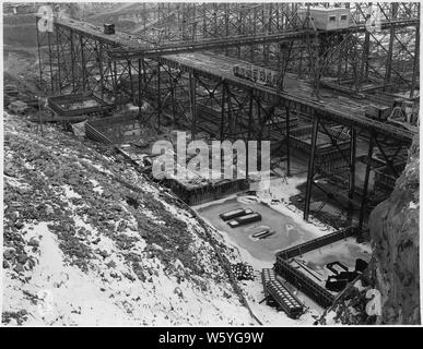 Vista guardando verso est per mostrare casa potenza di blocchi in calcestruzzo sul lato ovest. Il posizionamento inferiore traliccio attraversa la casa potenza sito.; Portata e contenuto: fotografia dal volume due di una serie di album di foto per documentare la costruzione del Grand Coulee Dam e i relativi lavori sul bacino di Columbia progetto. Foto Stock