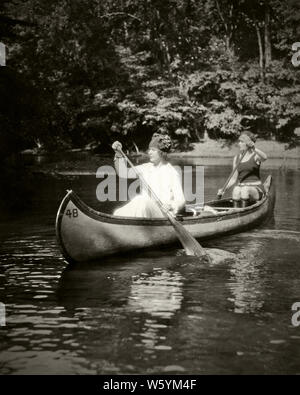 1920s due giovani donne PADDLING una canoa insieme sul fiume di Bosco - c1110 HAR001 HARS TEAMWORK CANOA atleta di stile di vita rurale femmine salubrità spazio copia amicizia a mezza lunghezza LADIES FITNESS FISICO DELLE PERSONE STREAM ATHLETIC fratelli sorelle Trasporto B&W CANOA ATTIVITÀ FISICA felicità avventura per il tempo libero di ricreazione di forza su un pari livello di flessibilità concettuale muscoli elegante cooperazione supporto MID-adulto metà donna adulta PADDLING RELAX convivere bosco giovane donna adulta in bianco e nero di etnia caucasica CREEK HAR001 in vecchio stile Foto Stock