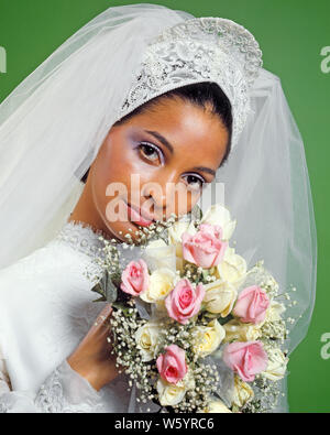 Anni Settanta ritratto afro-americano di pizzo sposa testiera velo abito bianco bianco bouquet di rose rosa bimbo di respiro guardando la fotocamera - KB8742 HAR001 HARS SPAZIO COPIA LADIES matrimonio persone velo soffio fiducia cerimonia nuziale con il contatto visivo sogni di felicità di testa e spalle allegro BRIDES CUSTOM afro-americani afro-americano tradizionale Nozze Nuziale occasione BLACK etnia sposando orgoglio sorrisi testiera gioioso rito di passaggio elegante BABY la WED sposarsi matrimonio giovane donna adulta HAR001 in vecchio stile afro-americani Foto Stock