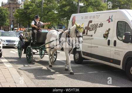 Carrozza a cavallo che passa attraverso il traffico nella città di Monaco, Sonnenstraße. Foto Stock