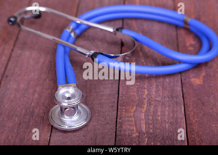 Medical stetoscopio e compresse isolato su sfondo di legno Foto Stock