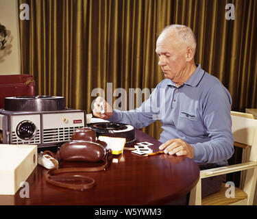 Anni sessanta SENIOR UOMO A CASA LA VISUALIZZAZIONE DI MODIFICA DI VACANZA IN FAMIGLIA 35MM diapositive foto accanto a telecamera e proiettore - KS5139 HAR001 HARS ELDER SALUBRITÀ HOME VITA spazio copia di metà lunghezza persone ispirazione telecamere CARING MASCHI SENIOR uomo adulto SENIOR SENIOR DONNA SUCCESSO TEMPO LIBERO attività di abilità divertimento proiettore i sogni di felicità OLDSTERS SCOPERTA ANTICA HOBBY in viaggio di piacere e di interesse scelta GETAWAY emozione hobby conoscenza ricreazione passatempo giostra orgoglio piacere vacanze anziani diapositive rivedendo collegamento concettuale fotografia accanto al visualizzatore elegante 35MM uomo anziano creatività ELECTRONIC Foto Stock