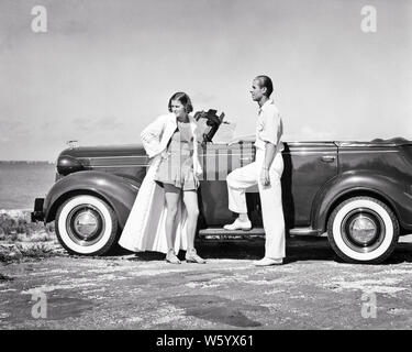 1930s di CLASSE GIOVANE IN PIEDI DA autovettura convertibile sulla spiaggia donna che indossa ROMPER e ciniglia abito uomo vestito di bianco - m6136 HAR001 HARS sposa abito sposa mariti di lusso DEI PNEUMATICI DEGLI STATI UNITI spazio copia amicizia a tutta lunghezza LADIES PERSONE DEGLI STATI UNITI D'AMERICA AUTOMOBILE MASCHI TUTTA LA FIDUCIA IL TRASPORTO B&W TEMPO PARTNER OFF AVVENTURA STILI DI SVAGO E DI VIAGGIO AUTOS GETAWAY WHITEWALL RICREAZIONE RICCHEZZA DA IN SU vacanze affluente Automobili Veicoli eleganti ciniglia mode di classe mid-adulto metà uomo adulto a metà donna adulta convivere vacanze mogli IN BIANCO E NERO Foto Stock