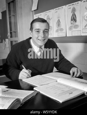 Anni sessanta sorridente ragazzo studente di biologia classe LIBRO prendere appunti in notebook - s15401 HAR001 INFORMAZIONI HARS LIETA GIOIA LIFESTYLE spazio copia di metà lunghezza persone ispirazione maschi di biologia ragazzo adolescente espressioni di fiducia B&W contatto visivo successo felicità allegro resistenza di rilevamento eccitazione del progresso delle conoscenze in direzione di orgoglio in occasione di alta scuola sorrisi alte scuole ancora concettuale vita prendendo appunti coinvolti gioiosa adolescente elegante impaziente la crescita I RAGAZZI IN BIANCO E NERO di etnia caucasica HAR001 in vecchio stile Foto Stock