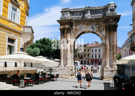 I turisti a piedi attraverso il romano arco trionfale del Sergii a Pola, Croazia Foto Stock