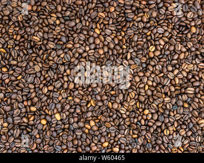 Rosolare i chicchi di caffè texture. Mix di buio e di medie caffè torrefatto in grani. Può essere usato come cibo e bevanda sfondo. Vista dall'alto. Foto Stock