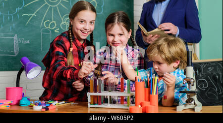 Fare esperimenti con liquidi nel laboratorio di chimica. Ai bambini di esperimenti scientifici. L'istruzione. torna a scuola. laboratorio di chimica. bambini felici insegnante. Utilizzando le moderne tecnologie. Foto Stock