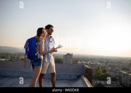 Felice coppia giovane di viaggiatori tenendo la mappa in mani Foto Stock