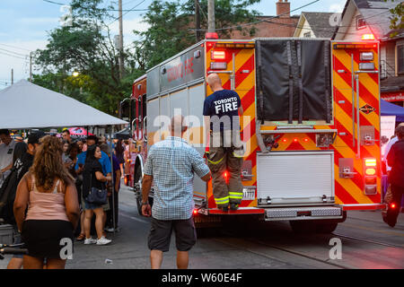 Un firetruck cerca di rendere il suo modo attraverso la strada affollata a Toronto il Streetfest, parte del Jazzfest music festival nel mese di luglio 2019. Foto Stock