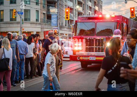 Un firetruck cerca di rendere il suo modo attraverso la strada affollata a Toronto il Streetfest, parte del Jazzfest music festival nel mese di luglio 2019. Foto Stock
