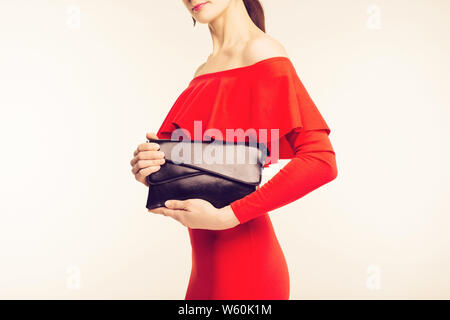 Woman in Red Dress holding nero elegante borsetta Foto Stock