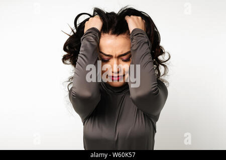 Dolori sgradevoli. Triste infelice bella donna tenendo la sua fronte pur avendo mal di testa isolata Foto Stock