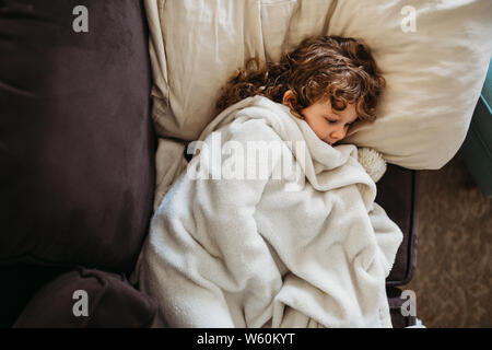 Ragazza giovane la posa sul lettino mentre ammalati Foto Stock