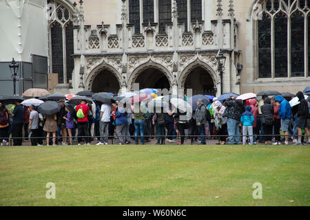 Londra, Regno Unito. Il 30 luglio, 2019. I turisti aspettando pazientemente sotto la pioggia la formazione di lunghe code per inserire l'Abbazia di Westminster. Credito: Joe Kuis: Alamy / News Foto Stock