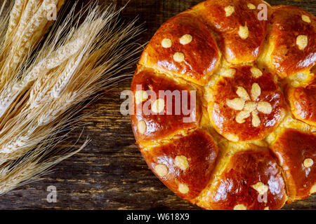 Un covone di grano e challah ebraico su scuro dello sfondo in legno Foto Stock