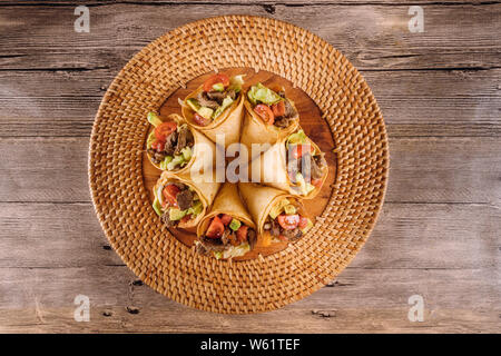 Una sana insalata di manzo in tortilla coni in basked e pomodoro Foto Stock