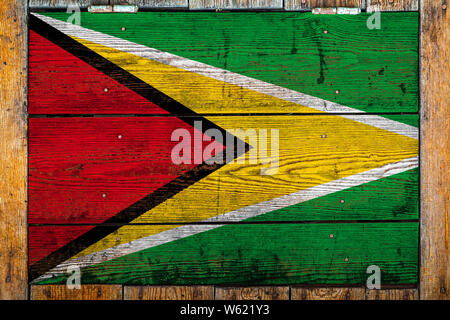 Bandiera Nazionale della Guyana su una parete in legno sfondo.Il concetto di orgoglio nazionale e il simbolo del paese.Bandiera dipinta su una staccionata in legno con metallo Foto Stock