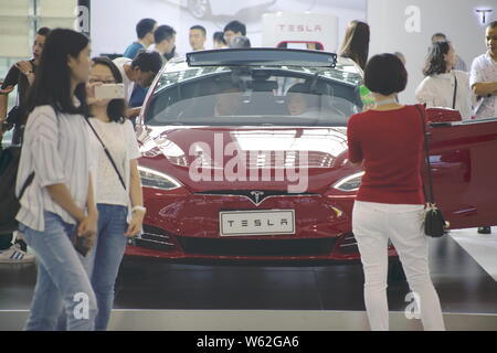 --FILE -- gente guarda a un modello di Tesla S auto elettrica sul display durante il XIV Cina (Guangzhou) Salone Internazionale dell'Automobile, noto anche come Au Foto Stock