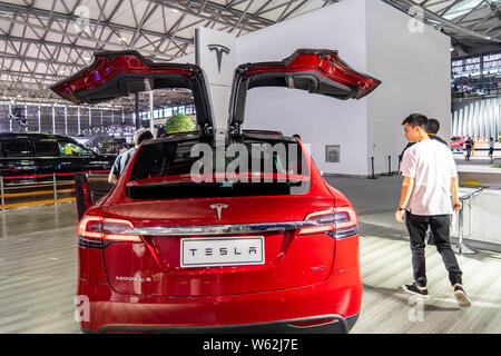 --FILE--persone guardano una Tesla Model X auto elettrica sul display durante una mostra a Shanghai in Cina, 28 settembre 2018. Tesla è in proc Foto Stock