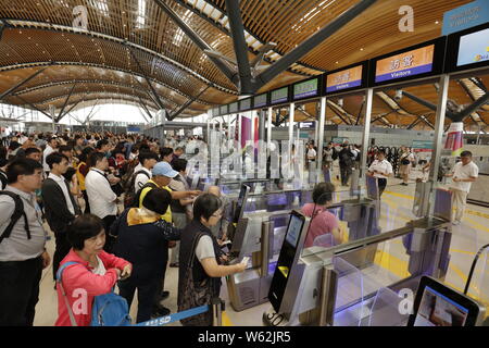 I passeggeri in coda fino a prendere un pullman da Kwoon Chung autobus oltre la più lunga del mondo cross-ponte del mare, la Hong Kong-Zhuhai-ponte di Macao, a Hong Kong, C Foto Stock