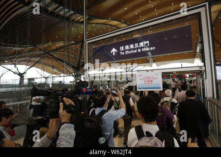 I passeggeri in coda fino a prendere un pullman da Kwoon Chung autobus oltre la più lunga del mondo cross-ponte del mare, la Hong Kong-Zhuhai-ponte di Macao, a Hong Kong, C Foto Stock