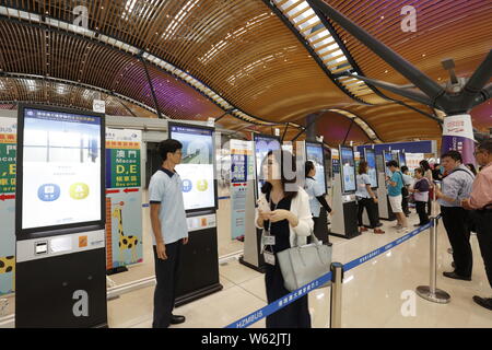 I passeggeri in coda fino a prendere un pullman da Kwoon Chung autobus oltre la più lunga del mondo cross-ponte del mare, la Hong Kong-Zhuhai-ponte di Macao, a Hong Kong, C Foto Stock