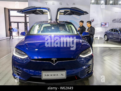 --FILE--persone guardano una Tesla Model X auto elettrica sul display durante una mostra a Shanghai in Cina, 28 settembre 2018. Tesla è in proc Foto Stock