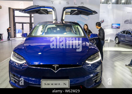 --FILE--persone guardano una Tesla Model X auto elettrica sul display durante una mostra a Shanghai in Cina, 28 settembre 2018. Tesla è in proc Foto Stock