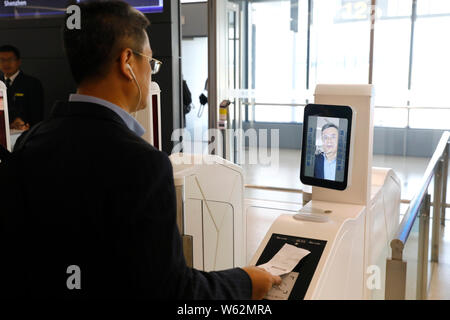 Un passeggero che scandisce la sua carta d'imbarco su un self-service di salire a bordo di una macchina equipaggiata con il riconoscimento facciale della capacità a T1, terminale di Shanghai ho Foto Stock