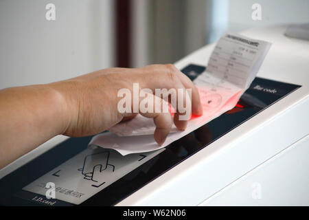 Un passeggero che scandisce la sua carta d'imbarco su un self-service di salire a bordo di una macchina equipaggiata con il riconoscimento facciale della capacità a T1, terminale di Shanghai ho Foto Stock