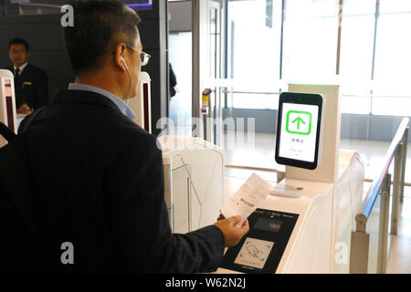 Un passeggero che scandisce la sua carta d'imbarco su un self-service di salire a bordo di una macchina equipaggiata con il riconoscimento facciale della capacità a T1, terminale di Shanghai ho Foto Stock