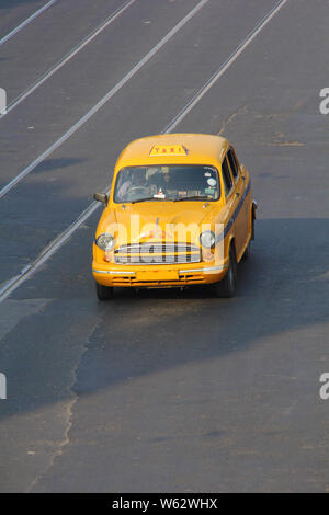 Yellow taxi moving on the road, Kolkata, West Bengal, India Stock Photo