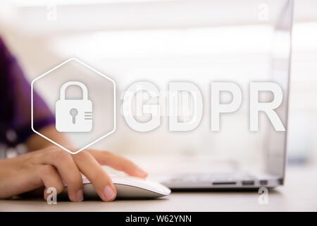 Il PILR. Protezione dei dati il Regolamento. Cyber security e il concetto di privacy. Close up di giovani mani femminili usando il mouse remoto per computer portatile in ufficio moderno ne Foto Stock