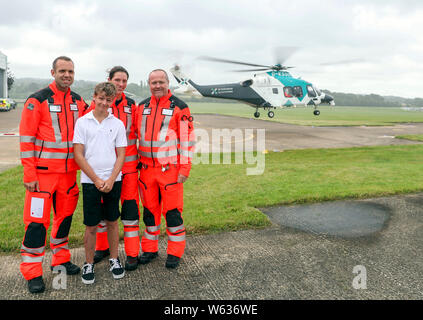 Joe Pelham, 14, incontra i membri del team medico Richard Lyon e paramedici Sam Taylor e David Wright dall'Air Ambulance Kent Sussex Surrey, che ha salvato la sua vita a loro Redhill base in Surrey. Joe è stato trattato dal team dopo che egli era stato colpito da un auto mentre il ciclismo. Foto Stock