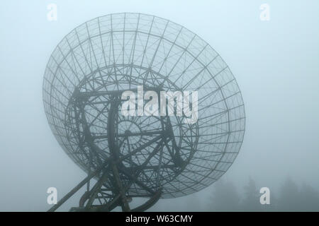 Close up di un radiotelescopio su un nebbioso giorno Foto Stock