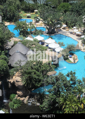 Sun City resort e hotel in Sud Africa piscina di lusso per ospiti con acqua turchese e circondato da alberi in un ambiente tropicale Foto Stock