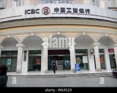 --FILE--un dipendente cinese è visto di fronte a una succursale di industriale e banca commerciale (ICBC) a Chongqing Cina, 18 dicembre 2017. Nuovi casi in Foto Stock