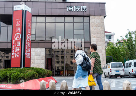 --FILE--pedoni a piedi passato una bollitore ristorante di Hai di Lao a Shanghai in Cina, il 24 maggio 2018. Haidilao International Holding Ltd, mainlan cinese Foto Stock