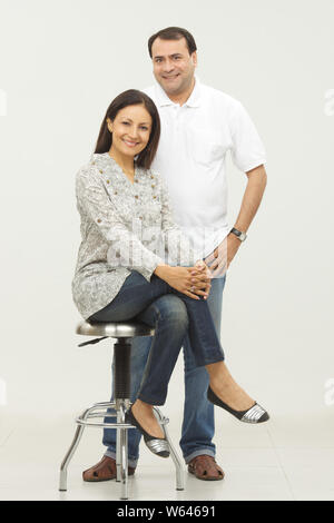 Woman sitting on stool with her husband Stock Photo