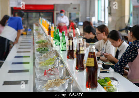 Gli studenti mangiare nastro trasportatore hotpot, letteralmente 'Rotazione hot pot,' in una mensa di Xi'an università di finanza ed economia in Xi'an City, Northwest Ch Foto Stock