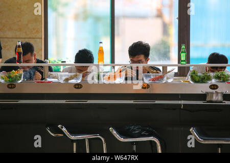 Gli studenti mangiare nastro trasportatore hotpot, letteralmente 'Rotazione hot pot,' in una mensa di Xi'an università di finanza ed economia in Xi'an City, Northwest Ch Foto Stock