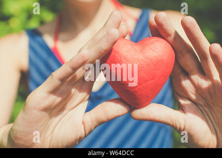 Il rapporto e l'amore concetto - womans mani cuore rosso Foto Stock