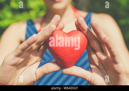 Il rapporto e l'amore concetto - womans mani cuore rosso Foto Stock