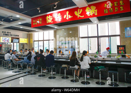 Gli studenti mangiare nastro trasportatore hotpot, letteralmente 'Rotazione hot pot,' in una mensa di Xi'an università di finanza ed economia in Xi'an City, Northwest Ch Foto Stock