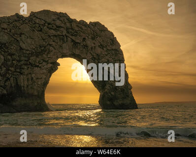 Durdle porta al tramonto. Pietra calcarea naturale arco su Jurassic costa di Dorset. Guardando ad ovest verso Portland Bill. West Lulworth. Mare del Nord. Regno Unito. Chiudere Foto Stock