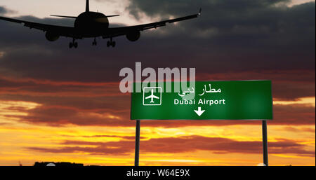 Silhouette di aeroplano di atterraggio in Dubai, Emirati Arabi Uniti, Emirati arabi uniti. Città arrivo con direzione aeroporto di cartello e il tramonto in background. Viaggio e tran Foto Stock